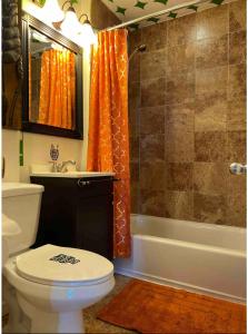 uma casa de banho com um WC, um lavatório e um chuveiro em Aloha of Falls Church em Falls Church