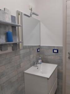 uma casa de banho com um lavatório branco e um espelho. em Soleil Royal piano terra em Viareggio
