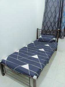 a bed in a room with a blue and white at Homestay baitijannati in Pasir Mas