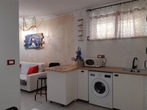 uma cozinha com máquina de lavar e secar roupa num quarto em Soleil Royal piano terra em Viareggio