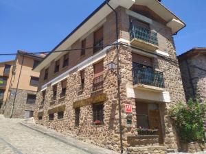 stary kamienny budynek po stronie ulicy w obiekcie Apartamento Turistico Luar 1 w mieście El Rasillo