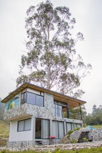 Una casa con un árbol encima. en Santa Helena Iscala, en Chinácota
