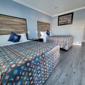 pokój hotelowy z 2 łóżkami i niebieskimi ścianami w obiekcie Guest Harbor Inn- Port Of Los Angeles San Pedro w mieście San Pedro