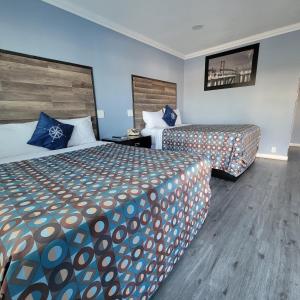 a hotel room with two beds and blue walls at Guest Harbor Inn- Port Of Los Angeles San Pedro in San Pedro