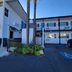 サンペドロにあるGuest Harbor Inn- Port Of Los Angeles San Pedroの駐車場内のヤシの木が二本ある建物
