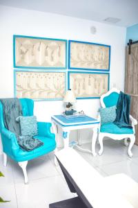 sala de estar con sillas azules y mesa en Miami Boho Beach Place en Hialeah