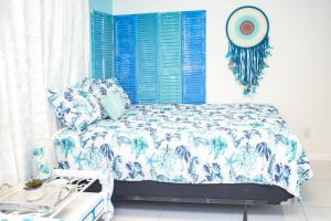 a bedroom with a bed with blue and white sheets at Miami Boho Beach Place in Hialeah