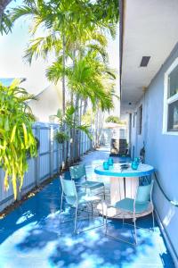 a patio with a table and chairs and palm trees at Miami Boho Beach Place in Hialeah