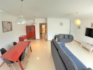 een woonkamer met een tafel en stoelen en een bank bij Algarve modern T1 apartment with balcony in Albufeira in Albufeira