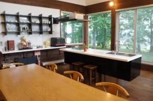 a kitchen with a large wooden table and a counter at Phytoncide Morinokaori in Furano