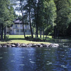 a house sitting next to a body of water at Solvikens Pensionat in Ingelstad