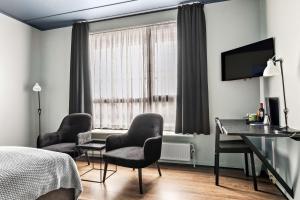 1 dormitorio con escritorio, sillas y 1 cama en Best Western Royal Holstebro en Holstebro