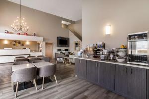 a restaurant with a counter with chairs and a kitchen at SureStay Hotel by Best Western Grants in Grants