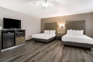a hotel room with two beds and a flat screen tv at SureStay Hotel by Best Western Grants in Grants