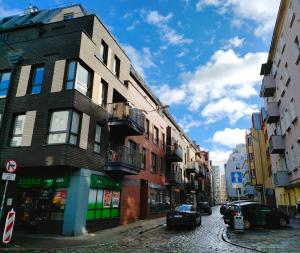 a building on a street with cars parked on the street at Apartament dla 1-4 osób w Golden House in Wrocław