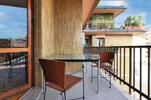 a balcony with a table and chairs on a balcony at Appartamento elegante e spazioso zona Solari in Milan