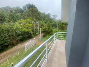 balcón con vistas a un bosque en Quatro Estações Hospeda - Casa Manancial Campos do Jordão, en Campos do Jordão