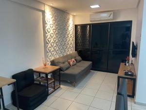 ein Wohnzimmer mit einem Sofa und einem Tisch in der Unterkunft Apart. Dois quartos na Ponta Verde in Maceió