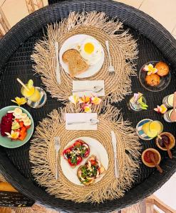 a table with plates of food and eggs on it at Villa Bali Santai in Kerobokan