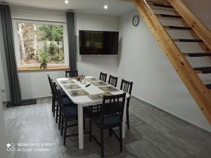 a dining room with a white table and chairs at Apartameny Wiktoria i Nikola w Karwiku in Pisz