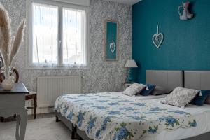 1 dormitorio con 2 camas y pared azul en chambres d hotes les papillons en Évron