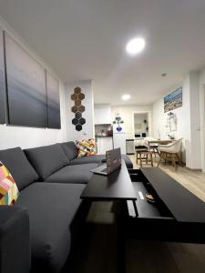 een woonkamer met een bank en een tafel met een laptop bij Artistic Digital Getaway - Patio & GREAT Location! in Lissabon