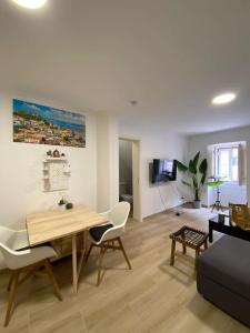 sala de estar con mesa, sillas y sofá en Artistic Digital Getaway - Patio & GREAT Location!, en Lisboa