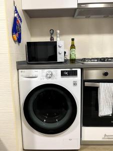 a kitchen with a washing machine and a microwave at Artistic Digital Getaway - Patio & GREAT Location! in Lisbon