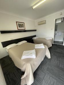 ein Zimmer mit 2 Betten und Handtüchern darauf in der Unterkunft Kelso Hotel in Kelso