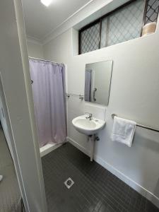 een badkamer met een wastafel, een douche en een spiegel bij Kelso Hotel in Kelso