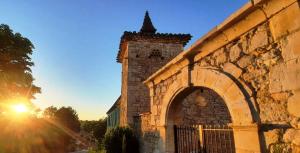 an old stone building with a gate and a sunset at DOMAINE DE LEJOS - Portes d'Albi in Lamillarié