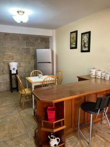 cocina con mesa, sillas y nevera en Apartamento #1 Portal de Occidente, en Quetzaltenango