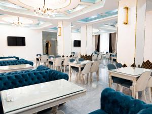 une salle à manger avec des chaises et des tables bleues dans l'établissement Reikartz Amirun Tashkent, à Tachkent