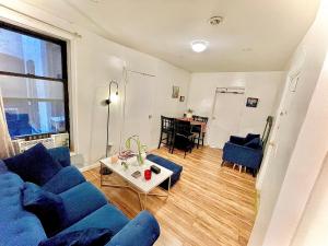 a living room with a blue couch and a table at Big Bedroom Best Location ! - Free Parking and first floor in Queens