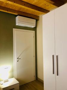 a room with a white door and a air conditioner at Residenza La Corte in Pizzighettone