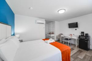 1 dormitorio con cama blanca y manta naranja en The Mariner Suites #24, en Hollywood