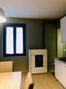 a room with a kitchen with a table and a microwave at Residenza La Corte in Pizzighettone