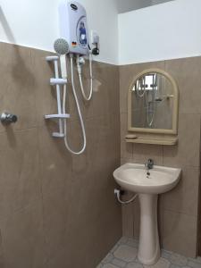 uma casa de banho com um chuveiro, um lavatório e um espelho. em Yaarl Holiday em Jaffna
