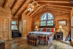 una camera da letto in una baita di tronchi con letto e camino di Blue Ridge Bliss- Spacious Cabin, Pets, Hot Tub! a Blue Ridge