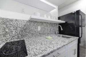 a kitchen with a sink and a black refrigerator at Peaceful Studio by the Beach with Parking - M25 in Hollywood
