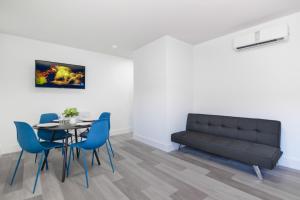 a dining room with a black couch and a table and chairs at Peaceful Studio by the Beach with Parking - M25 in Hollywood