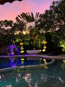 a swimming pool with a fountain and some plants at Villa Bali Santai in Kerobokan