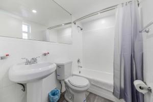 a white bathroom with a toilet and a sink at Peaceful Studio by the Beach with Parking - M25 in Hollywood +8 photos