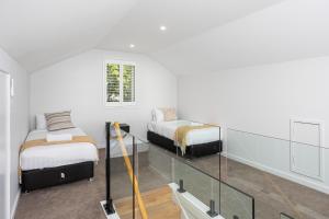 a white room with two beds and a glass staircase at New luxury home, walking distance to CBD in Wagga Wagga