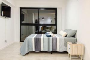 1 dormitorio con 1 cama con manta a rayas y mesa en Hermoso Departamento en Salta Capital (4B) en Salta