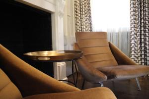 sala de estar con sillas, mesa y chimenea en The Houston Wagga, en Wagga Wagga