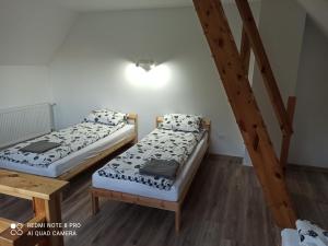 two beds in a room with a staircase at Apartameny Wiktoria i Nikola w Karwiku in Pisz