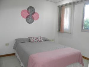 1 dormitorio con 2 camas y manta rosa en Zona shopping del Sol, Asunción, en Asunción