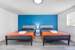 een slaapkamer met 2 bedden en oranje en blauwe muren bij The Mariner Suites #27 in Hollywood