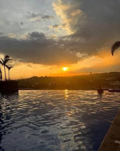 puesta de sol sobre una piscina con puesta de sol en LA VISTA BANGI Homestay, en Bangi